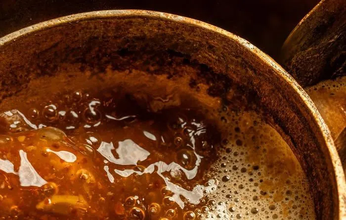 Arabic coffee bubbling in a brass dallah