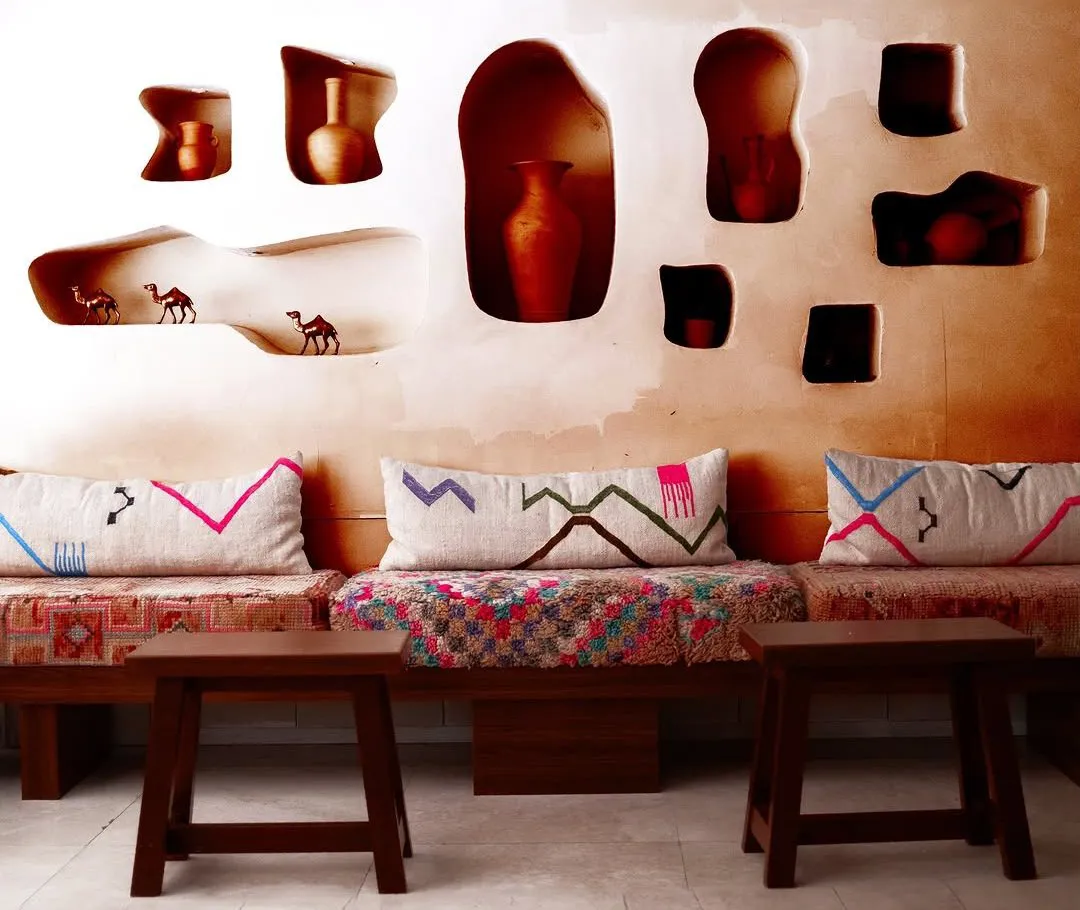 The Mazj diwaniya in Shuwaikh, with carved wall niches, pottery, woven cushions and wooden stools